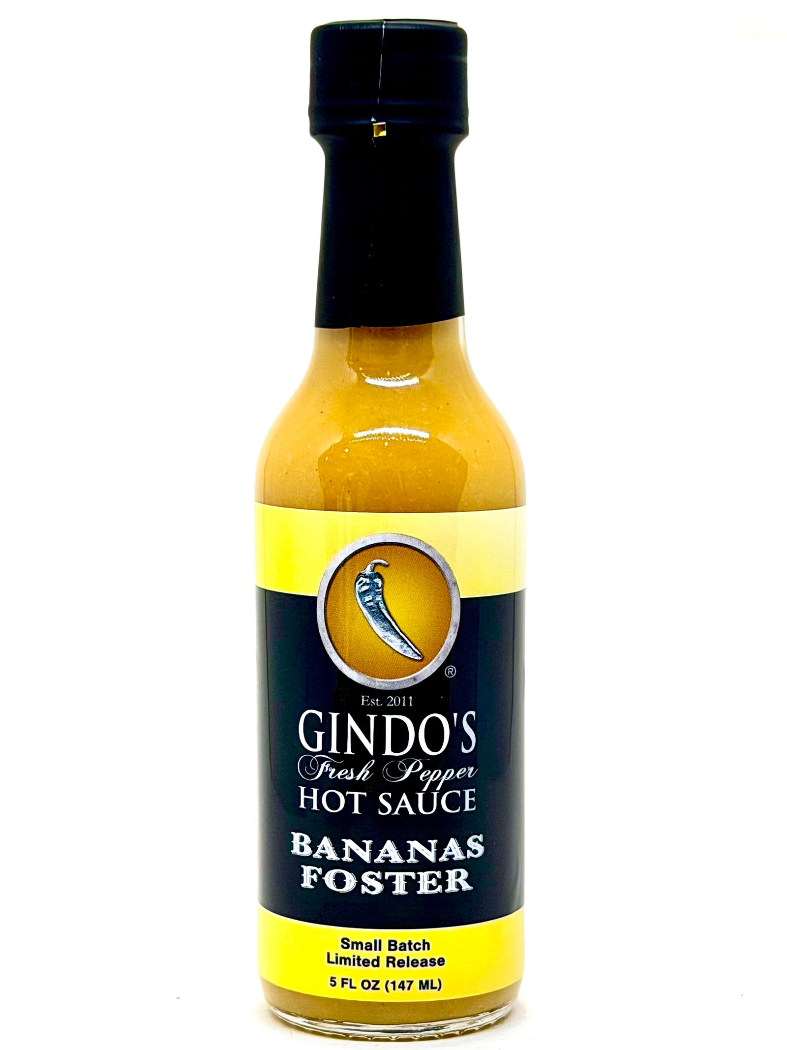 Bottle of Gindo's Bananas Foster hot sauce on a white background
