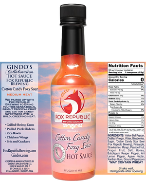 A bottle of Fox Republic Collaboration Hot Sauce (Cotton Candy Foxy Sour) centered against a split-color background showing the brand's website on the left and the nutrition facts label on the right.