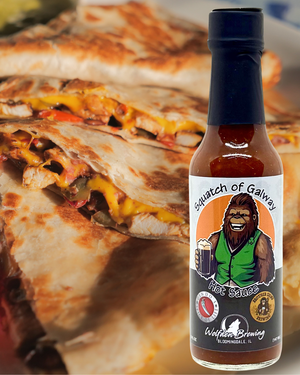 Bottle of Squatch of Galway hot sauce with a quesadilla in the background