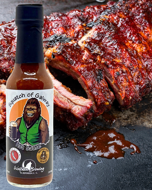 Hot sauce bottle labeled 'Squatch of Galway' with ribs in the background